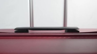 Yakından çekilmiş bir video kırmızı bir bavula iki fermuar çektiğini gösteriyor. Bagajı güvenli bir şekilde açıp kapatmaya odaklanacağız..
