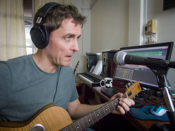 Medium view Independent erkek müzisyen, kendi stüdyosukayıt sisteminde gitar ve vokal leri kaydeder. Teknoloji geliştikçe ve maliyetler azaldıkça birçok yapımcı artık ev stüdyosu ortamlarında albüm ve şarkı kaydediyor.. 