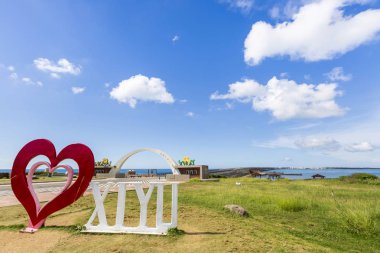 mavi bulutlu gökyüzü altında çim üzerinde aşk xixyu heykel