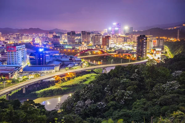 緑の丘の上に照らされた夜の都市 — ストック写真