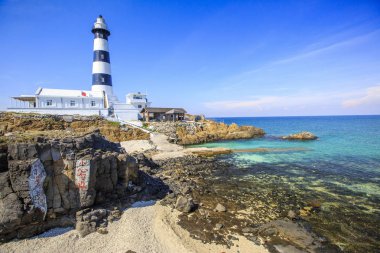 parlak güneş ışığında okyanus üzerinde deniz feneri