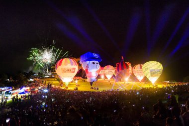 kalabalık ile gece sahnesinde ışıklı hava balonları