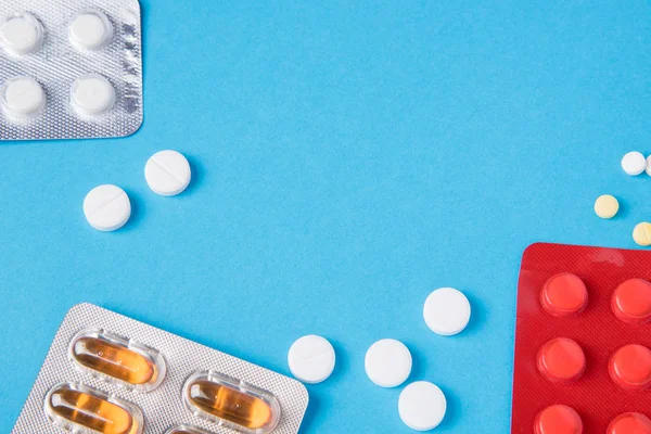 Farklı tabletler ve pill ağrı kesici paket ve onsuz mavi bir arka plan üzerinde