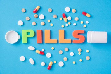 Farklı tabletler ve pill ağrı kesici paket ve onsuz mavi bir arka plan üzerinde