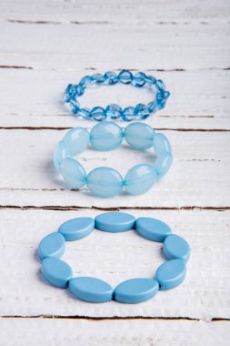 Birkaç güzel mavi bilezik boncuk Beyaz ahşap zemin üzerinde
