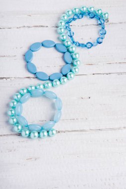 Birkaç güzel mavi bilezik boncuk Beyaz ahşap zemin üzerinde