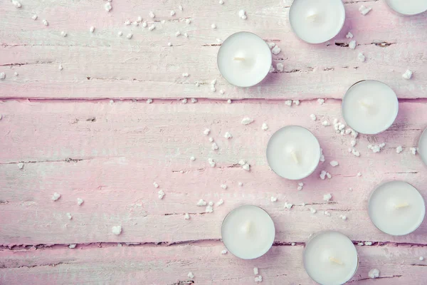 Ein Paar Flache Weiße Kerzen Auf Einem Schönen Rosa Holztisch — Stockfoto