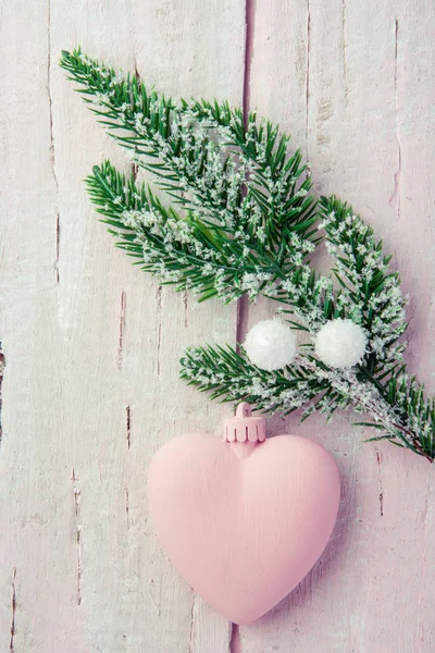 Köknar dalı ile ahşap bir pembe tablo olarak yeni yıl için güzel bir arka plan üzerinde beyaz toplar