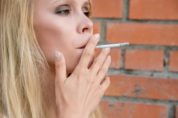 Krásná Mladá Blondýnka Kouří Cigaretu Bílé Cihlovou Zeď Pozadí Ulici — Stock fotografie
