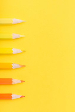 Makro fotoğraf sarı ve turuncu renk Kağıt arka plan üzerinde birkaç keskin kalemler