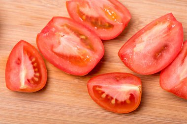 Beyaz zemin üzerinde bir ahşap tahta üzerinde sulu olgun kırmızı domates doğranmış