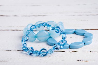 Birkaç güzel mavi bilezik boncuk Beyaz ahşap zemin üzerinde