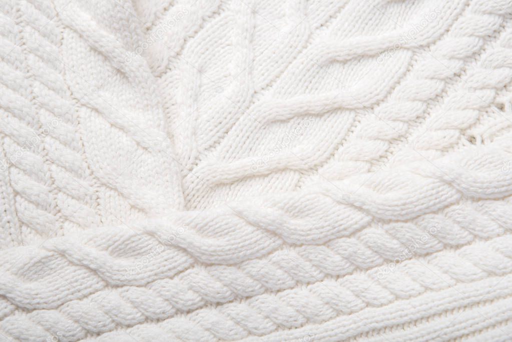 A beautiful fragment of a knitted texture of white color as an interesting background