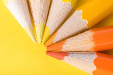 Makro fotoğraf sarı ve turuncu renk Kağıt arka plan üzerinde birkaç keskin kalemler