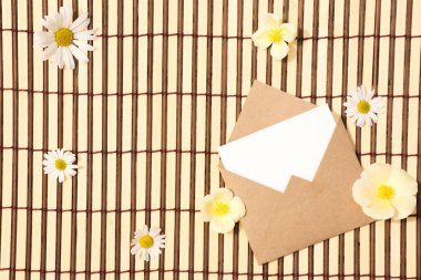 Zarf kraft kağıt güzel beyaz papatya çiçekleri ile boş bir ileti ile