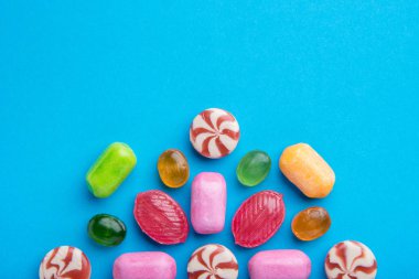 Çok çok renkli lezzetli karamelli şeker mavi bir arka plan üzerinde