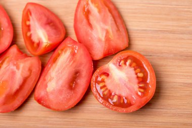 Beyaz zemin üzerinde bir ahşap tahta üzerinde sulu olgun kırmızı domates doğranmış