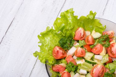 Taze sebze, şalgam, salatalık, domates, beyaz zemin üzerine maydanoz ve avokado lezzetli salata