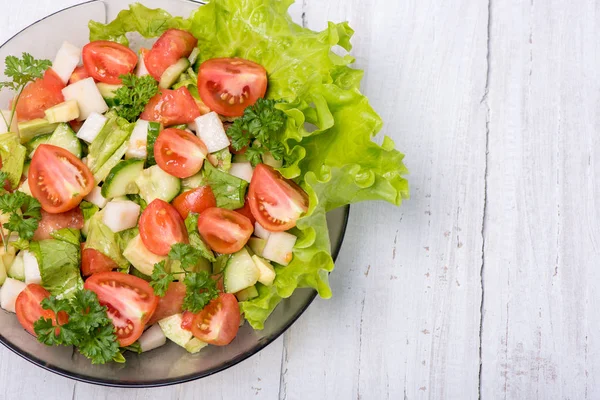 Taze sebze, şalgam, salatalık, domates, beyaz zemin üzerine maydanoz ve avokado lezzetli salata