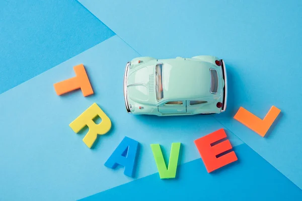 Carro Brinquedo Verde Letras Viagem Plástico Inscrição Fundo Papel Azul — Fotografia de Stock