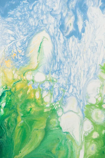 Beautiful abstract background of liquid acrylic in blue, white and green on canvas