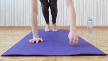 Güzel ince esmer kız mor bir halı üzerinde bir SLAT duruyor