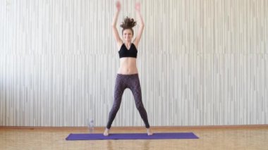 Güzel ince esmer kız mor bir halı üzerinde spor ve jimnastik dahil