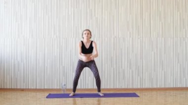 Güzel ince esmer kız mor bir halı üzerinde spor ve jimnastik dahil