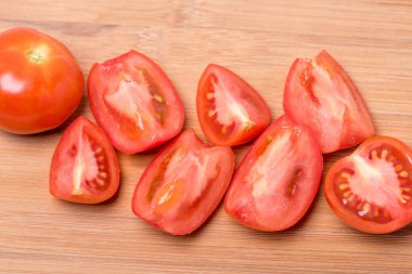 Beyaz zemin üzerinde bir ahşap tahta üzerinde sulu olgun kırmızı domates doğranmış