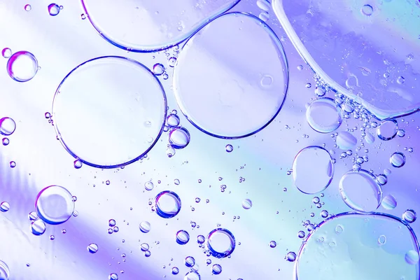 Belle macro photo de gouttelettes d'eau dans l'huile avec un bac violet — Photo