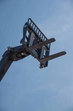 Sergi bir mavi gökyüzü karşı bir forklift kamyon siyah parçası