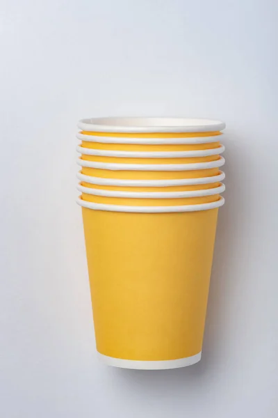 Copas de papel ecológicas amarillas para una fiesta sobre un fondo blanco — Foto de Stock