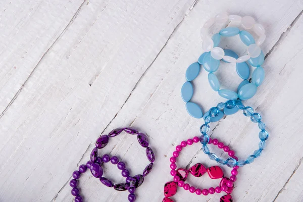 Several beautiful bracelets of beads and stones of blue, pink an — Stock Photo, Image