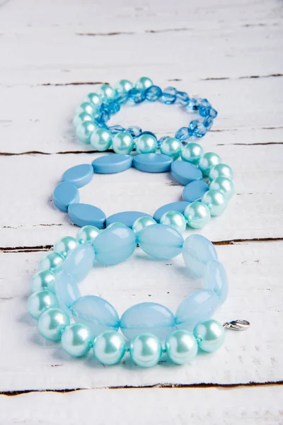Plusieurs beaux bracelets bleus de perles sur un fond en bois — Photo