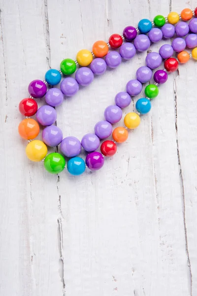 Colorful beautiful bright beads necklace on a wooden background — Stock Photo, Image