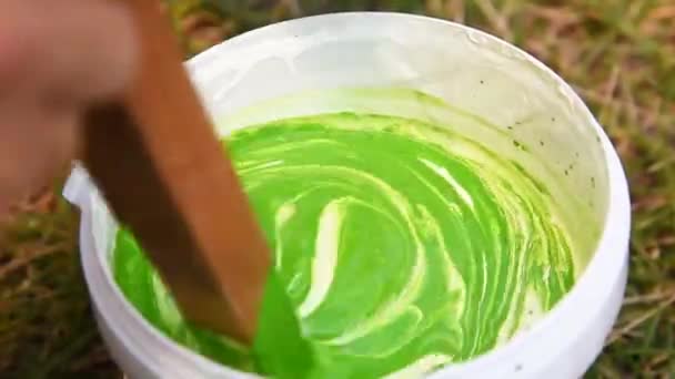 Weißer Acrylfarbe Gießen Und Die Grüne Farbe Mit Einem Holzstab — Stockvideo