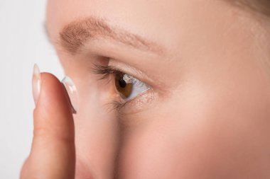 Kahverengi gözleri olan bir kız vizyon için bir kontakt lens giyer