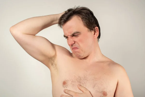 Hombre guapo con axilas malolientes sobre un fondo blanco —  Fotos de Stock