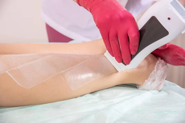 Ontharing Master in handschoenen van toepassing gesmolten Wax op vrouwelijke benen — Stockfoto