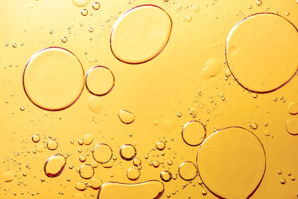 Belle macro photo de gouttelettes d'eau dans l'huile avec un bac jaune — Photo