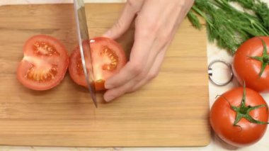 Ahşap bir tahta üzerinde metal bir bıçak ile salata için domates kesme kadın elleri üst görünümü