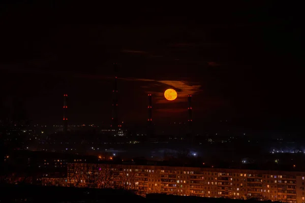 Hermosa salida de la luna en el fondo de las tuberías de fábrica y el ci — Foto de Stock