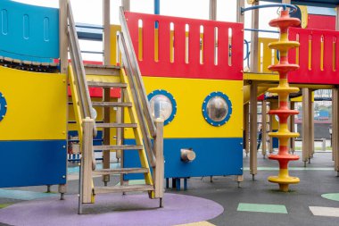 Yazın dışarıda, kauçuk zeminde tahta oyun parkı.