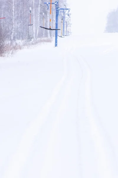 Impianti di risalita per sciatori e snowboarder in inverno su una collina innevata — Foto Stock