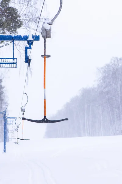 Ski-lift for skiers and snowboarders in winter on a snowy hill i