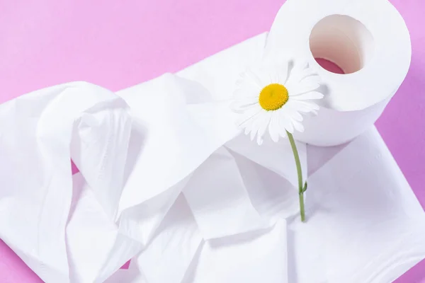 Papel higiénico perforado blanco con el aroma y la margarita en un rosa — Foto de Stock