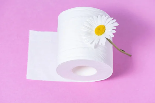 White perforated toilet paper with the scent and daisy on a pink — Stock Photo, Image