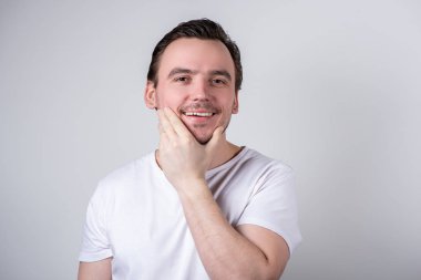 Beyaz t-shirt gülümseyen kıllar ile Yakışıklı adam