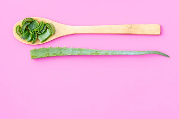 Plante médicinale aloe vera sur une cuillère en bois sur un fond rose — Photo