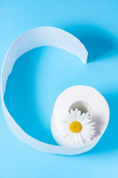 Papel higiénico perforado blanco con el aroma y la margarita en un azul — Foto de Stock